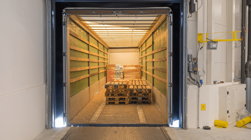 The inside of a truck with some boxes and pallets